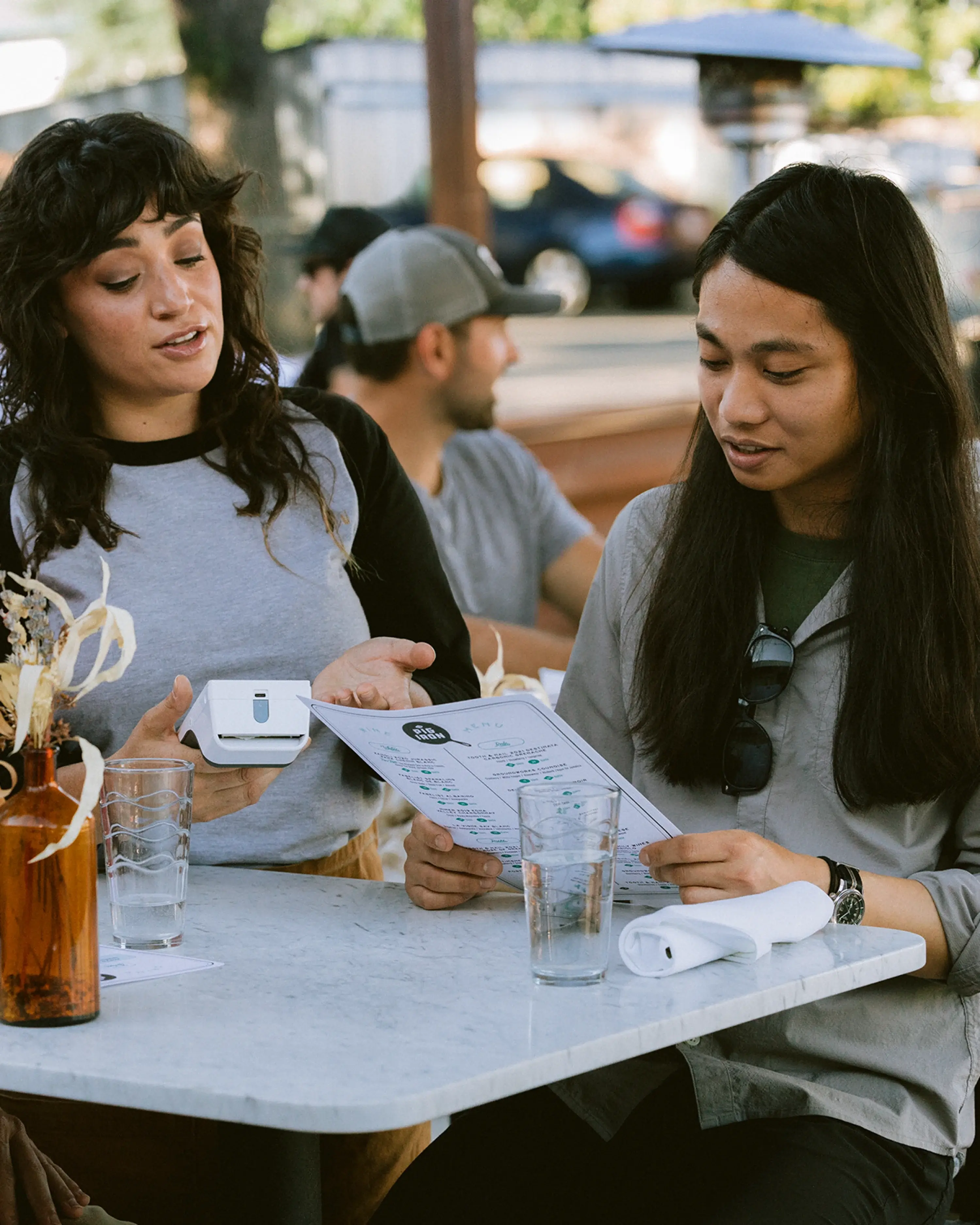 Server using Clover Flex at an outdoor table